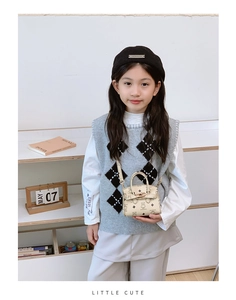 Detail of white mini bag featuring cute cartoon bear print and classic flap metal buckle