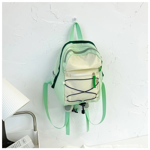 Detail of mint green and cream nylon backpack with elastic drawstrings and zipper pocket