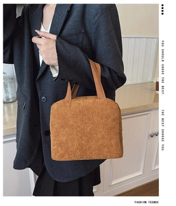 Detail of caramel corduroy tote bag texture held by model in professional suit