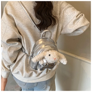 Mini sac à dos argenté métallisé avec lapin en peluche porté par le mannequin