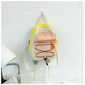 Detail of color-block kids backpack with pink pocket, yellow trim and orange zipper puller