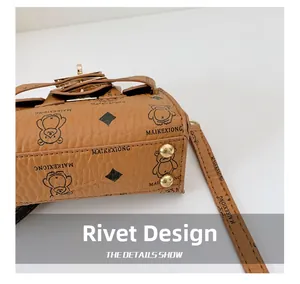 Detail showing brown leather texture with bear print and gold-tone base metal rivets