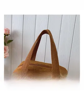 Detailed macro of brown corduroy tote bag featuring widened woven handles and metal zipper