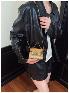 Close-up of golden sequin mini handbag for girls with 3D bow and elegant metal chain strap