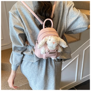 Mini sac à dos rose en similicuir avec peluche lapin blanc porté par un mannequin