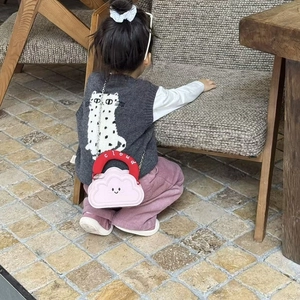 Close-up of pink cloud-shaped girl's crossbody bag with red handle and silver chain strap