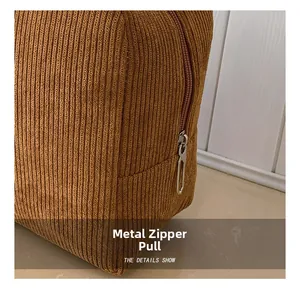 Detail of hardware zipper and vertical corduroy texture on brown tote handbag
