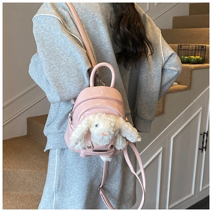 Détail du mini sac à dos rose avec un lapin en peluche blanc dans la poche avant