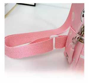 Gros plan sur la bandoulière en nylon rose et la boucle en plastique du sac pour enfant