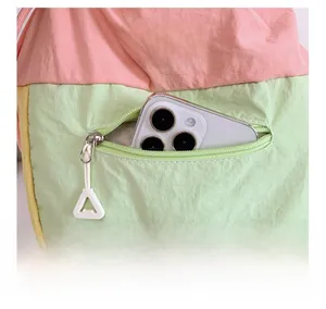 Détail de la poche avant du sac à dos à cordon montrant la capacité pour un smartphone