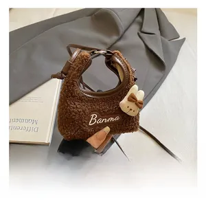 Close-up of brown plush bucket bag with rabbit doll and Banma embroidery detail