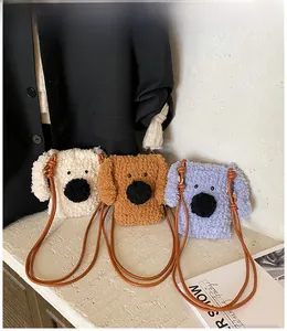 Détail de sacs bandoulière chiot en peluche bouclée en crème, caramel et bleu clair