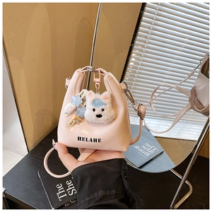 Détail du mini sac à main rose avec pendentif peluche et imprimés de lettres
