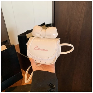 Gros plan d'un mini sac blanc avec broderie nœud rose et bordures en dentelle