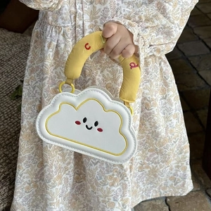 Close-up of cloud shaped kid's handbag with yellow embroidery and cute smiling face