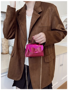 Detail of pink glitter girls handbag with bow and golden chain strap on model