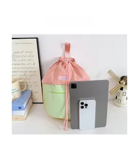 Comparaison de taille détaillée du sac à dos rose et vert avec iPad et téléphone