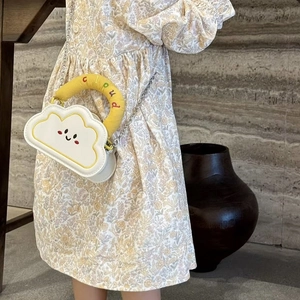 Detail of cute cloud-shaped kids handbag with embroidered handle and metal chain strap