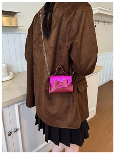 Detail of rose pink sequin bow crossbody bag with silver chain on fashion model outfit