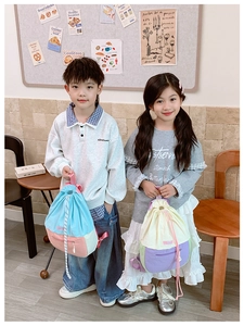 Détail d'un sac à dos bicolore avec cordon de serrage et poche zippée pour enfants en intérieur