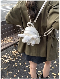 Détail du mini sac à dos crème avec une peluche de lapin et des ferrures argentées