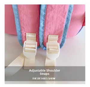 Close-up of adjustable shoulder straps with white plastic buckles on pink school backpack
