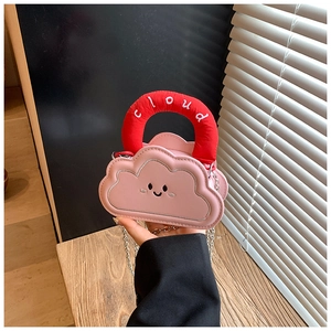 Detailed macro view of pink cloud mini bag with red plush handle and metal chain strap