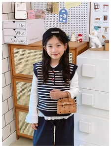 Kid's vintage outfit with a striped knit vest, lace shirt, and printed mini handbag