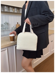 Detail of white corduroy tote bag with vertical texture and minimalist top handles