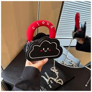 Detail of a cloud-shaped mini bag with a red handle and silver chain strap