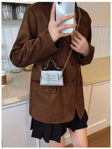 Mirror selfie showing the silver sequin mini handbag with a bow and metal chain strap