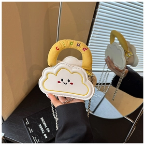 Detail of cute white cloud bag with yellow handles, smile face and silver chain strap
