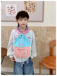 Garçon asiatique portant un sac à dos à cordon bicolore bleu et rose avec poches zippées