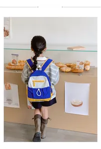 School backpack with navy blue and yellow contrast colors in a French bakery setting
