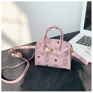 Detail of pink mini handbag with bear print, lychee texture, and golden twist lock clasp