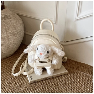 Détail du mini sac à dos crème avec une jolie poupée lapin en peluche en salopette