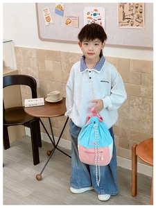 Détail d'un sac à dos à cordon bicolore bleu et rose porté par un enfant mannequin