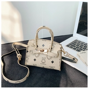 Detail view of mini cream bear print bag with golden clasp and adjustable shoulder strap