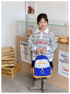 Detail view of large capacity kids backpack with colorful blue white yellow stitching