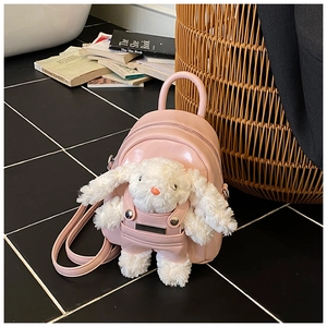 Détail d'un mini sac à dos en PU rose avec un joli lapin en peluche 3D blanc en salopette