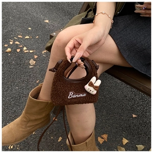 Detail of plush brown rabbit crossbody bag with Banma embroidery and slim leather strap