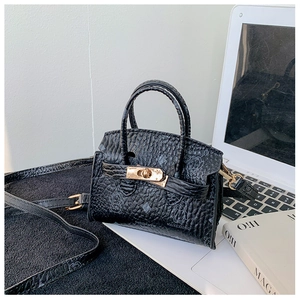 Detail of black pebbled leather kids handbag with bear print and gold twist lock closure