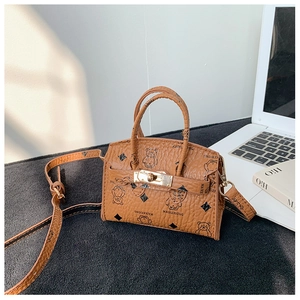 Detail of brown teddy bear pattern handbag with golden twist-lock and lychee texture