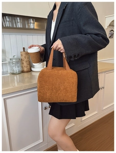 Detail of caramel corduroy handbag with vertical texture and sturdy carrying handles