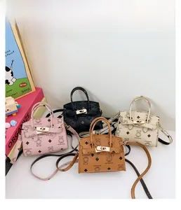 Detail of colorful mini bear handbags featuring lychee grain leather and gold turn-locks
