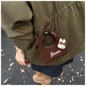 Detail of dark brown plush rabbit crossbody bag with Banma embroidery and cute charm