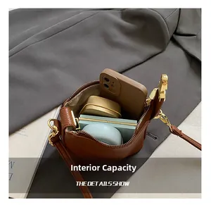 Interior view of brown pebble leather bag showing capacity for phone and cosmetics