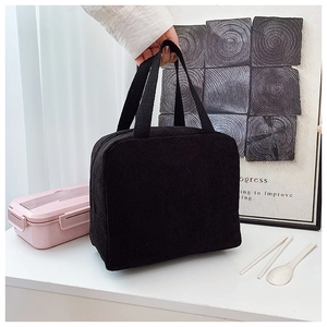 Detail of black corduroy tote bag showing thick striped texture and sturdy handles