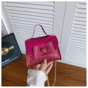 Close-up of rose pink mini sequin bow bag with golden chain strap for girls