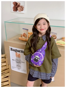 Vue détaillée du sac bandoulière violet pour enfants avec motifs ninja sur une fille